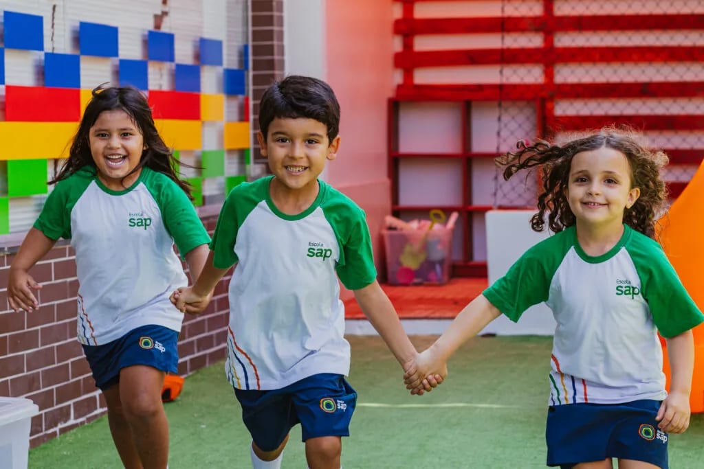 Crianças da Escola SAP correndo juntas no pátio